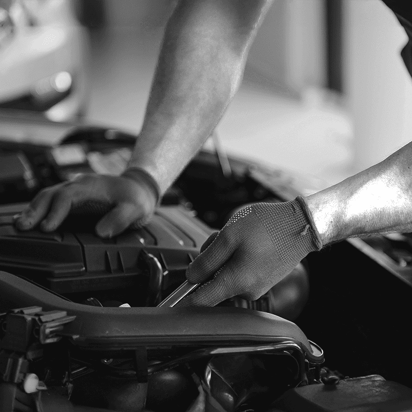 Gros plan sur les mains d'un mécanicien réparant un moteur