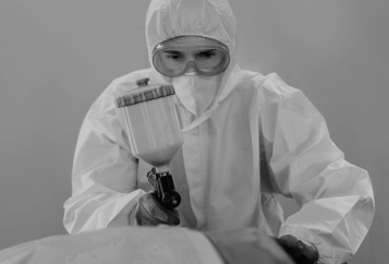 Un homme peint une carrosserie au pistolet à peinture pour carrosserie