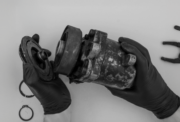 gros plan sur les mains d'un mécanicien qui tient une pièce de mécanique